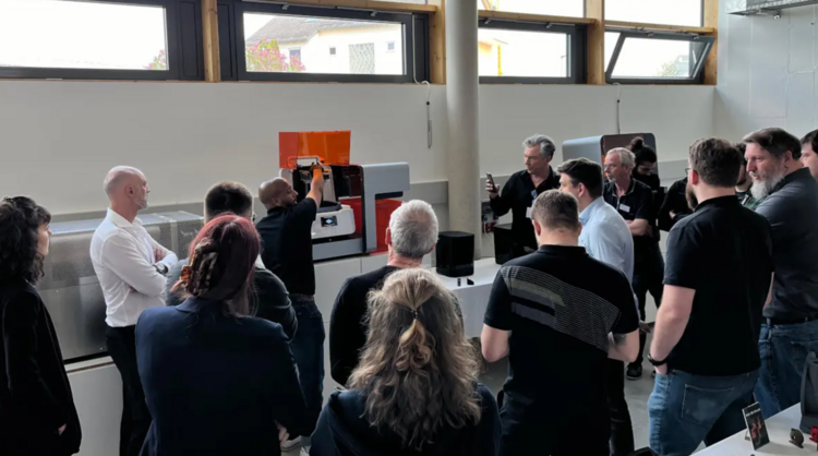 Moderne Bürogebäudefassade mit großen Glasfenstern und drei Fahnen, darauf steht 3D MODEL und Future Industries, bei klarem Himmel.